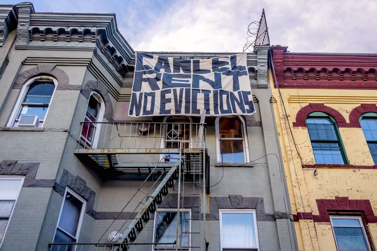 A "Cancel Rent No Evictions" banner hangs on an apartment building in Bushwick, N.Y., in July 2020
