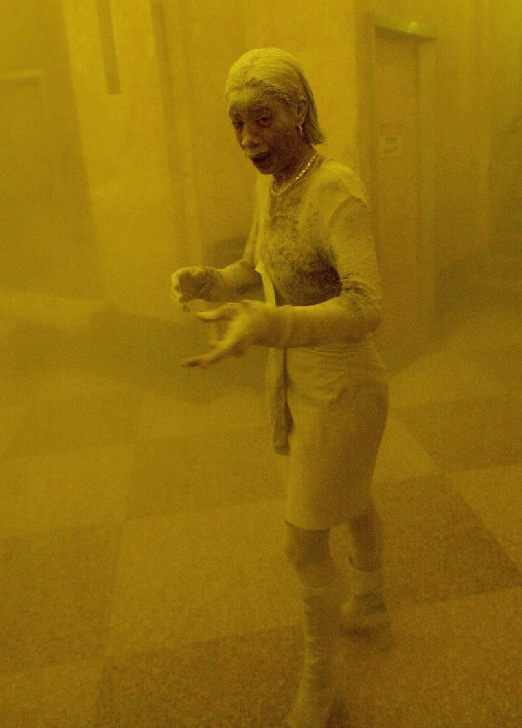 A woman covered in dust takes refuge in an office building after one of the towers collapsed.