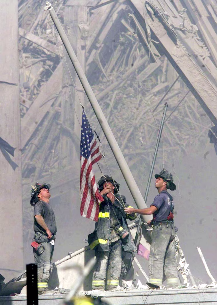 Firefighters raise a U.S. flag where the World Trade Center formerly stood on Sept. 11.
