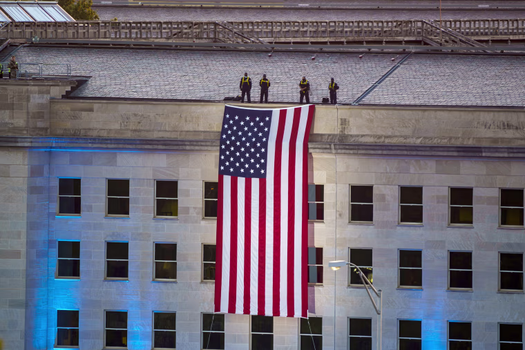 An American flag is unfurled at dawn over the Pentagon in Arlington, Va.