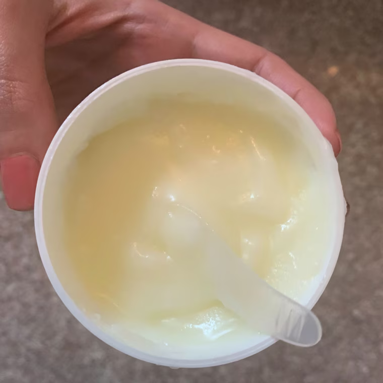 Writer Daniella Musacchio holding an open jar of the Junoo Cleansing balm