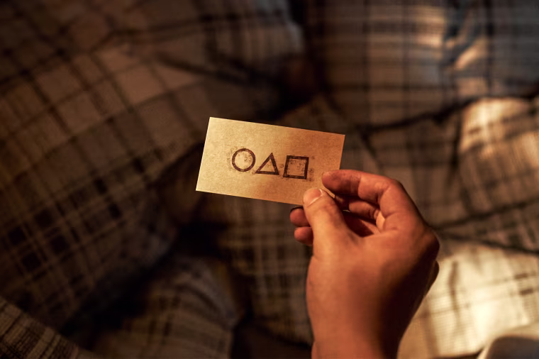 A card with a phone number on one side is given to the game's 456 participants in "Squid Game" on Netflix.