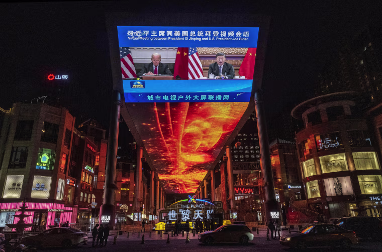 Image: A large screen displays President Joe Biden and China's President Xi Jinping during a virtual summit during a CCTV news broadcast outside a shopping mall on Nov. 16, 2021 in Beijing.