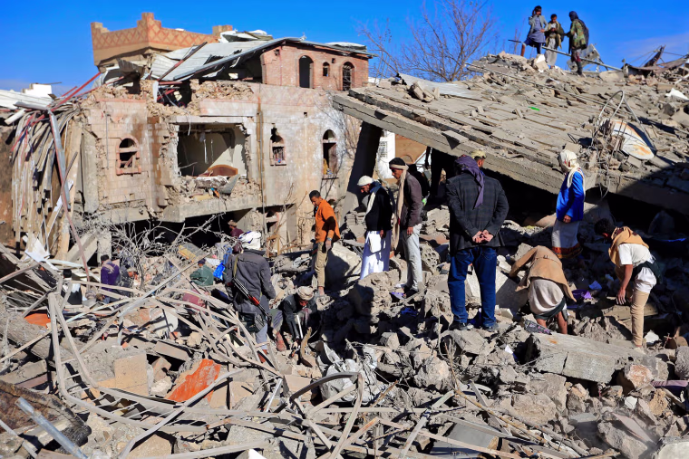 Image: Yemenis inspect the damage following overnight air strikes by the Saudi-led coalition targeting the Huthi rebel-held capital Sanaa, on Jan. 18, 2022.