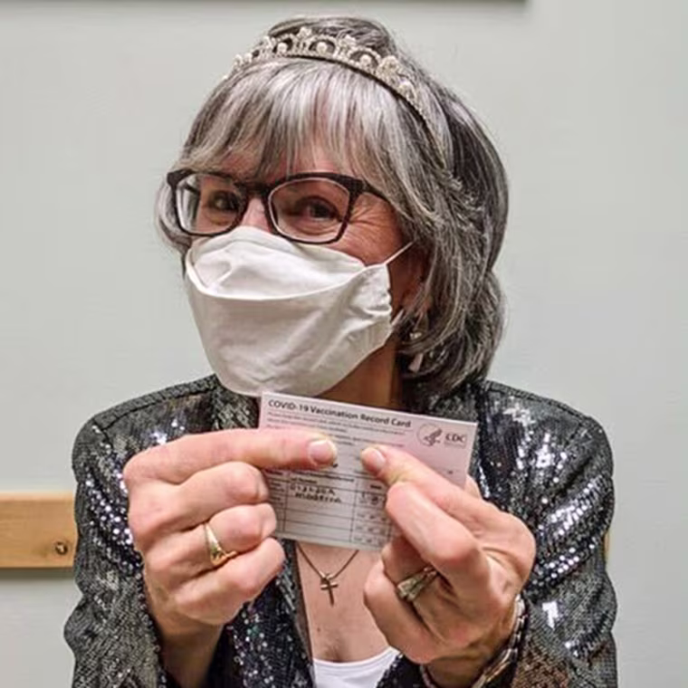 Terez Giuliana receives her first Covid-19 injection in January 2021, dressed in a tiara and sparkly jacket for the occasion.