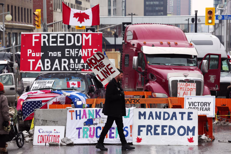 Image: A protester walks in front of parked trucks as demonstrators protest vaccine mandates implemented by Prime Minister Justin Trudeau on Feb. 8, 2022 in Ottawa, Canada.