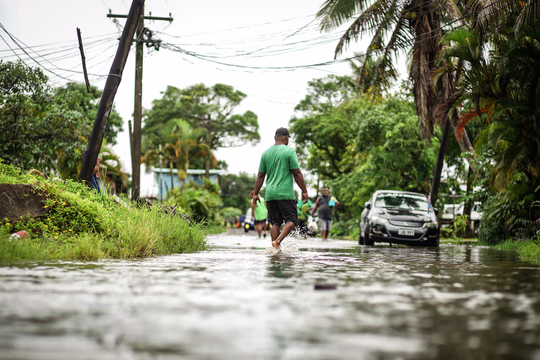 Residents wade through the flooded streets in Fiji's capital city of Suva on Dec. 16, 2020, ahead of super Cyclone Yasa.