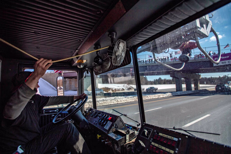 Cody Moores blows his horn as he drives past onlookers cheering on the convoy in Kennebunkport, Maine, on March 2, 2020.