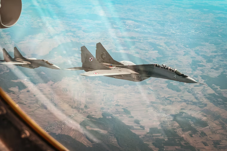 Two Polish Air Force MiG-29s fly alongside a B-52H Stratofortress assigned to the 69th Expeditionary Bomb Squadron at RAF Fairford, England, during a sortie in Poland, Feb. 24, 2022.