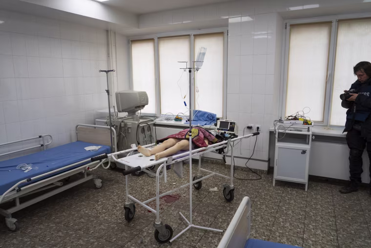 The lifeless body of a girl, killed from shelling of a residential area, lies in the city hospital in a photograph taken by Evgeniy Maloletka.