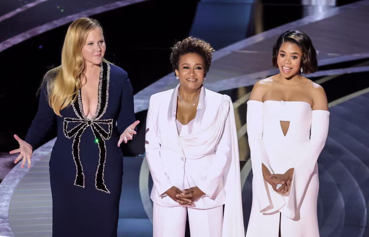 Co-hosts Amy Schumer, Wanda Sykes, and Regina Hall speak onstage during the Academy Awards in Los Angeles on Sunday.