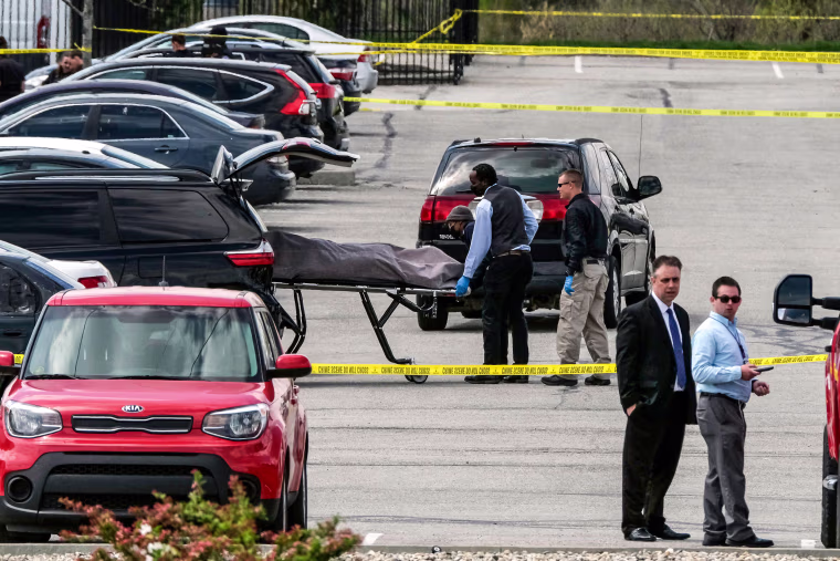 Officials load a body into a vehicle at the site of a mass shooting at a FedEx facility in Indianapolis, Indiana, on April 16, 2021.
