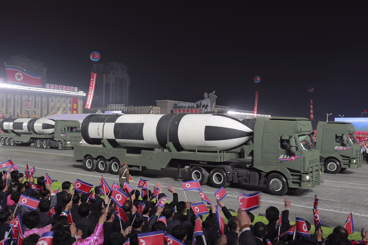 Military vehicles showcase ballistic missiles during the parade.