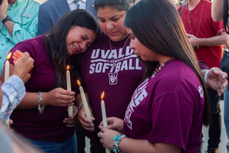 People comfort each other following a vigil held at the Uvalde County Fairplex in Uvalde, Texas, on May 25, 2022.
