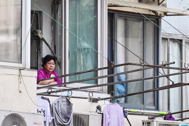 A resident looks out from her window