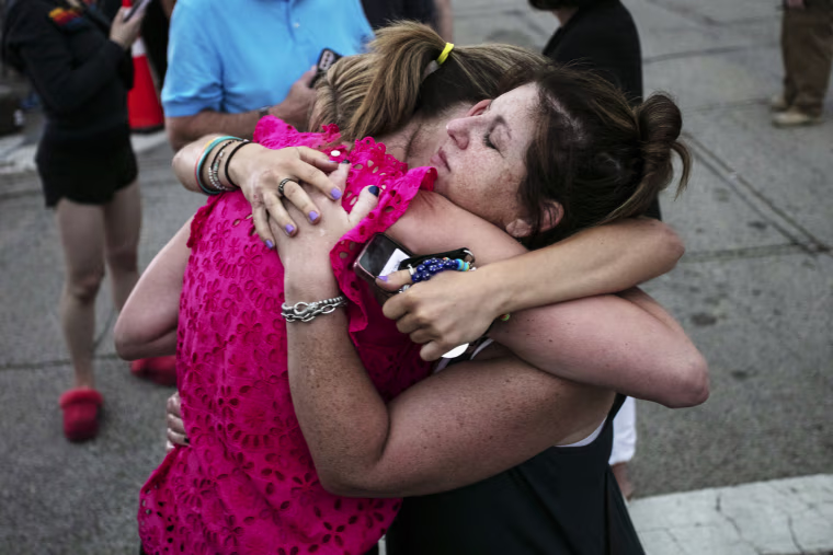 Image: Hillary Heller, Shannon Rowe and Lucy Heller embrace near the scene of a Fourth of July parade mass shooting on July 5, 2022 in Highland Park, Ill.