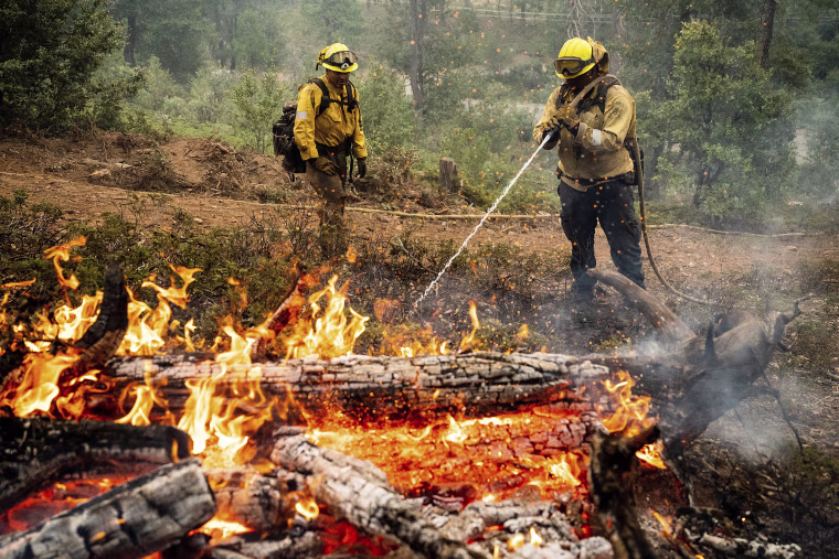 Firefighters mop up hot spots Monday while battling the Oak Fire in the Jerseydale community of Mariposa County, Calif.