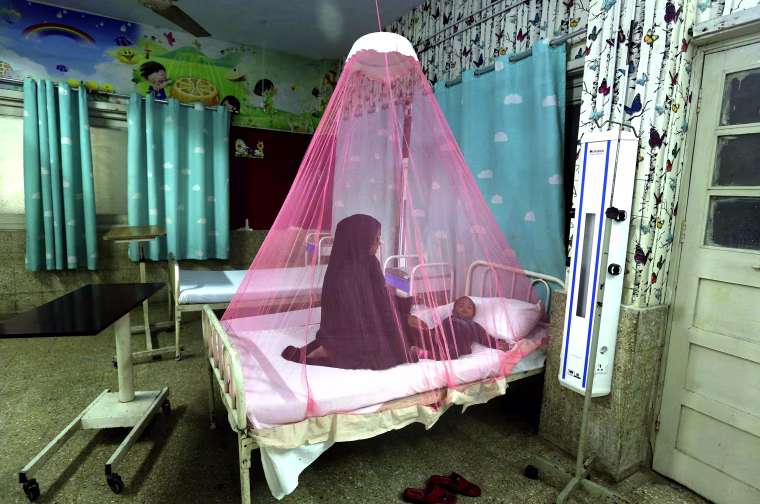 A mother takes care of her son, who suffers from dengue fever, a mosquito-borne disease, in a hospital in Karachi, Pakistan, on Nov. 22.