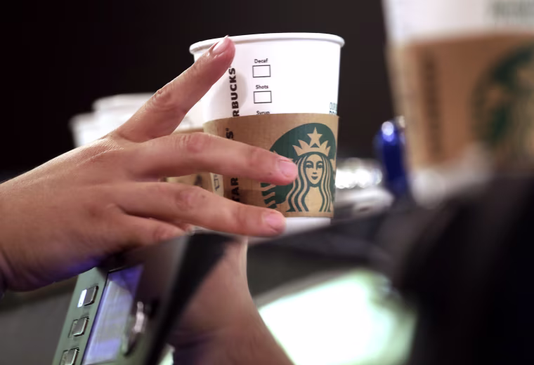 A barista reaches for an empty cup at Starbucks in the Pike Place Market in Seattle.