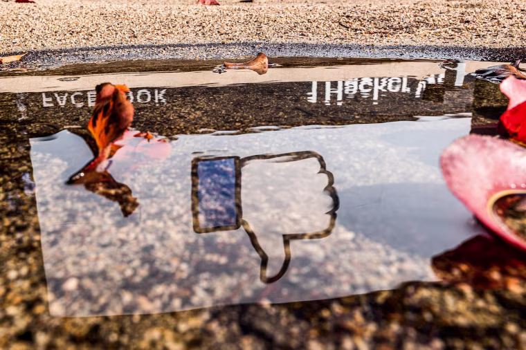 The Facebook logo reflected in a puddle at the company's headquarters in Menlo Park, Calif., on Oct. 25, 2021.