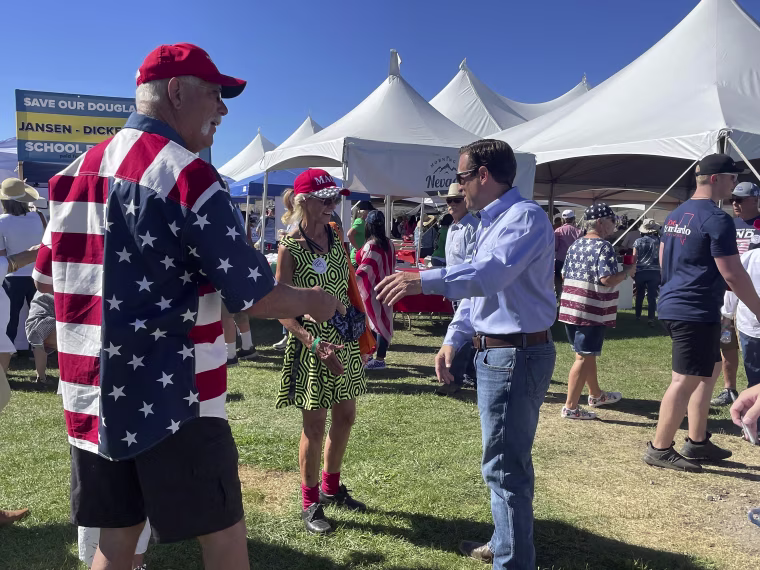 Republican Nevada Senate candidate Adam Laxalt, right, takes pictures with supporters at the seventh annual Basque Fry at the Corley Ranch on Saturday, Aug. 13, 2022, outside Gardnerville, Nevada.