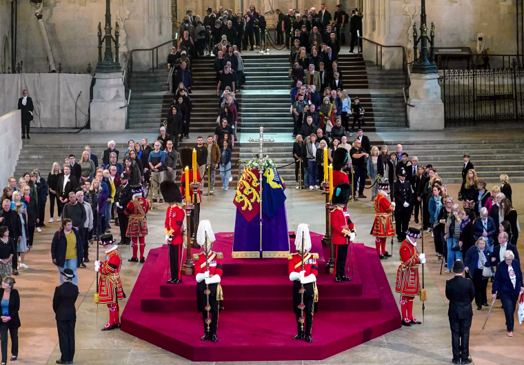 People file past the coffin of Queen Elizabeth II, draped in the Royal Standard with the Imperial State Crown and the Sovereign's orb and scepter, lying in state on the catafalque in Westminster Hall on Sept. 15, 2022, in London.