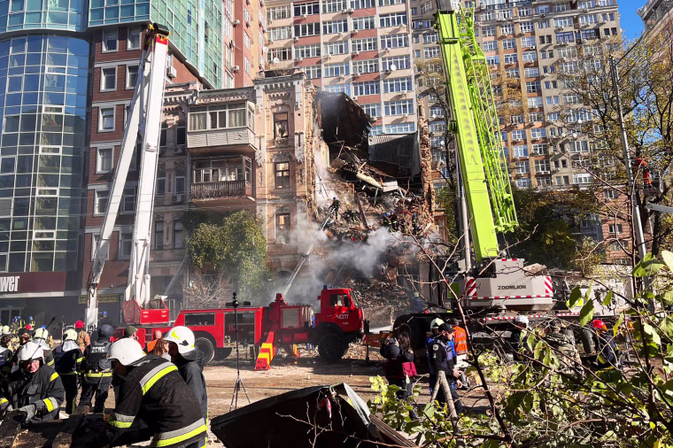 Rescue workers search for survivors after a drone attack on a residential building in Kyiv on Monday.