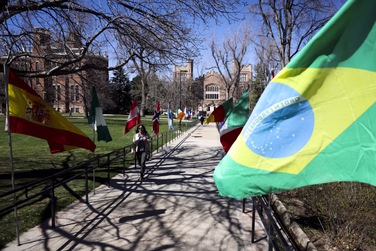 Students walk past flags on the University of Colorado campus
