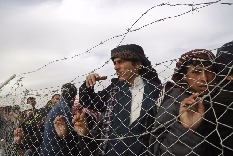 Iraqi refugees, who fled the Iraqi city of Mosul due to the fighting between government forces' and Islamic State group's jihadists, look from behind a fence at the UN-run al-Hol refugee camp in Syria's Hasakeh province, on Dec. 5, 2016.