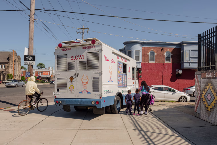 Children wait at an ice cream truck on a street corner in Philadelphia. Child welfare reform advocates have argued for providing parents with more resources to care for their families.