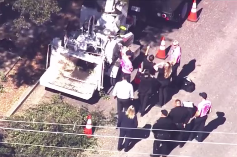 Investigators gather near a wood chipper after a tree trimmer died in Menlo Park, Calif., on Tuesday.