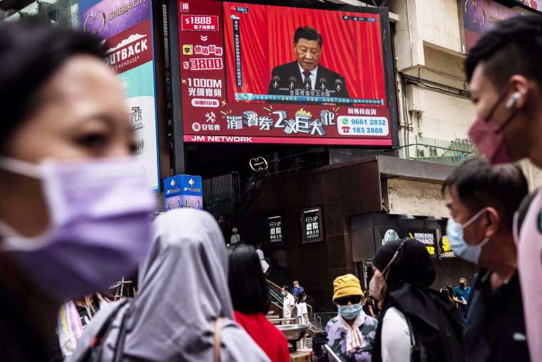 A telecast of Chinese President Xi Jinping plays on a screen in a street in Hong Kong