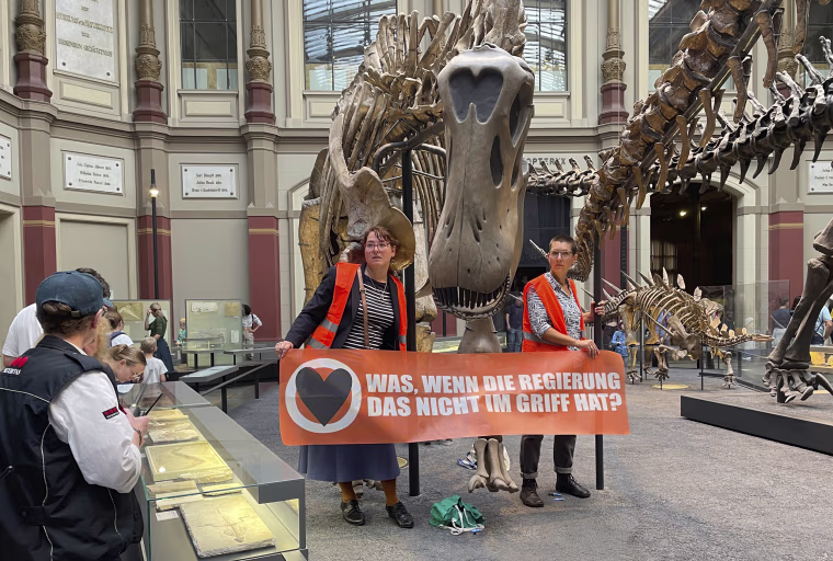 Two climate activists glued themselves to a dinosaur exhibit at Berlin's Museum of Natural History, on Oct. 30, 2022. 