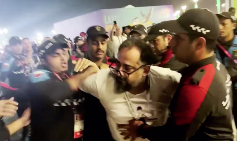 World Cup stadium security staffers pin down an Iranian wearing a protest T-shirt in Doha, Qatar, on Tuesday. 