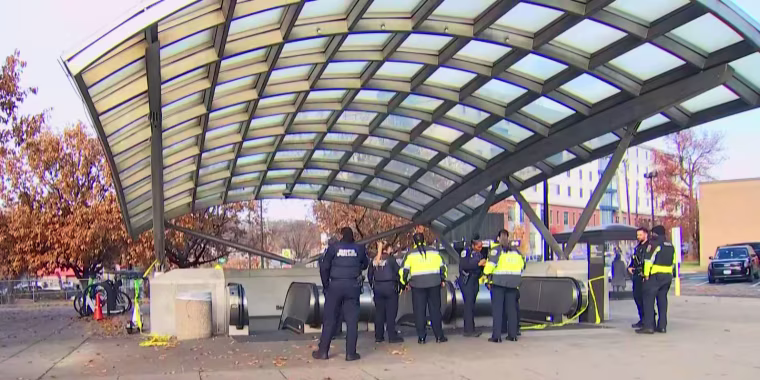Investigators stand outside the scene of a shooting at the Benning Road Metro station in  Washington, D.C.