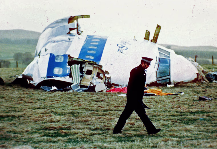 A police officer walks by the nose of Pan Am flight 103 in a field near the town of Lockerbie, Scotland