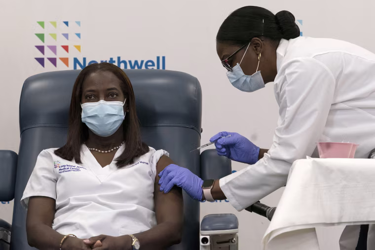 Sandra Lindsay is inoculated with the Pfizer-BioNTech COVID-19 vaccine by Dr. Michelle Chester, at Long Island Jewish Medical Center in Queens, N.Y., on Dec. 14, 2020.