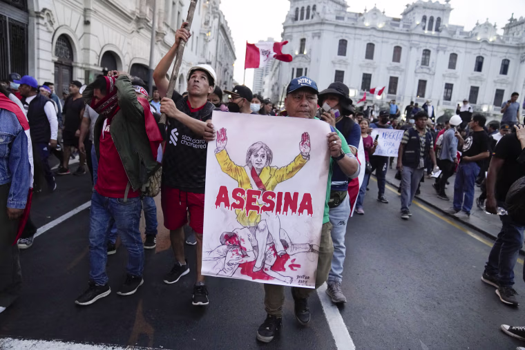 Supporters of ousted President Pedro Castillo hold a poster depicting Peru's new president, Dina Boluarte, along with sign "Killer" during a protest in Lima, Peru,