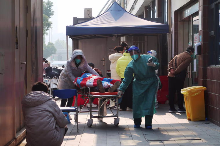 A medical worker moves a hospital bed carrying a person, outside a fever clinic of a hospital, after the government eased curbs on the coronavirus disease, in Wuhan, Hubei province, China December 10, 2022. 