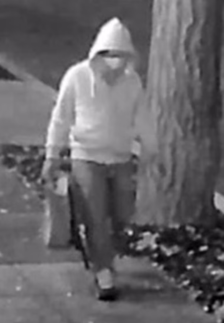 The unknown person wore a mask, glasses, gloves, a gray hooded sweatshirt and Nike Air Max Speed Turf shoes.
