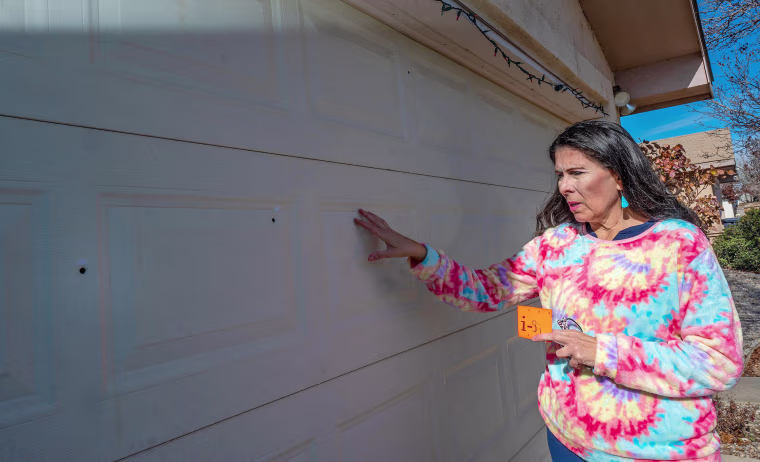 State Sen. Linda Lopez, D-Albuquerque, shows bullet holes in her garage door on Jan. 5, 2023, after her home was shot at.