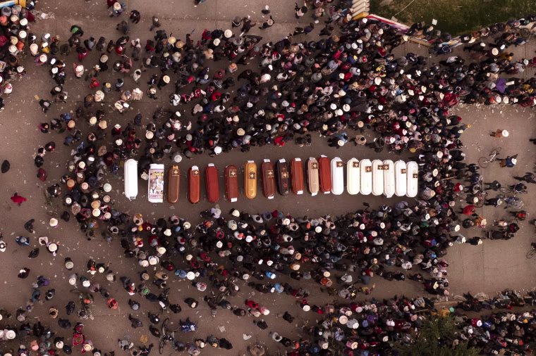 Residents surround coffins during a vigil for the more than a dozen people who died during the unrest in Juliaca, Peru, on Jan. 10, 2023.