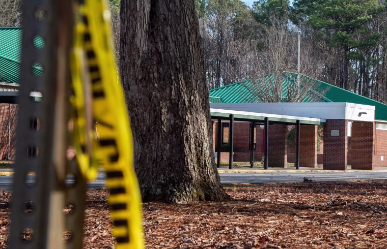Police tape hangs from a sign post outside Richneck Elementary School following a shooting on Jan. 7, 2023, in Newport News, Va.