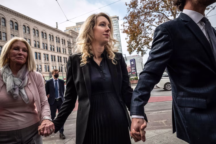 Elizabeth Holmes, founder and former CEO of blood testing and life sciences company Theranos, walks with her mother Noel Holmes and partner Billy Evans into the federal courthouse for her sentencing hearing on November 18, 2022 in San Jose, Calif.