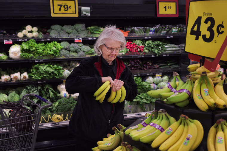 Pauline Doty picks bananas to add to the ones in her cart at a Food Lion in Columbia, SC., on Jan. 27, 2023.