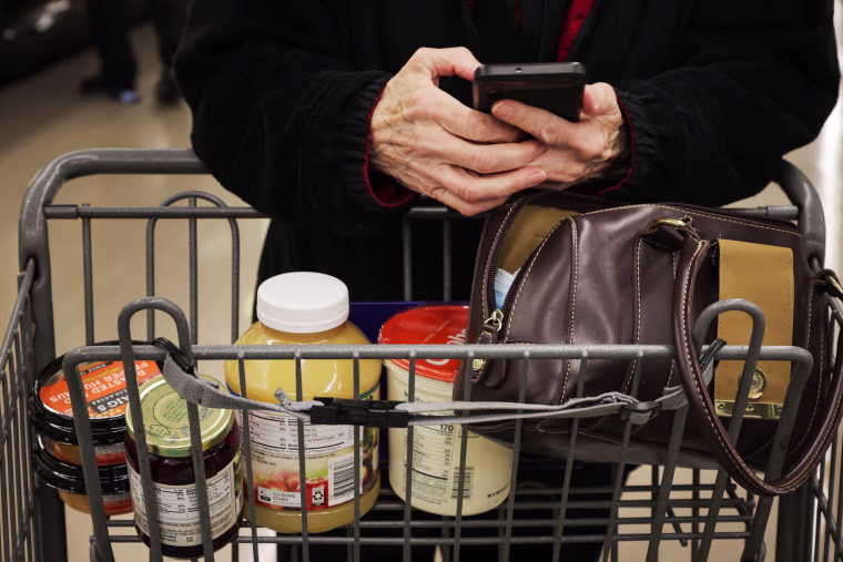 Pauline Doty consults her shopping list at a Food Lion in Columbia, S.C., on Jan. 27, 2023.
