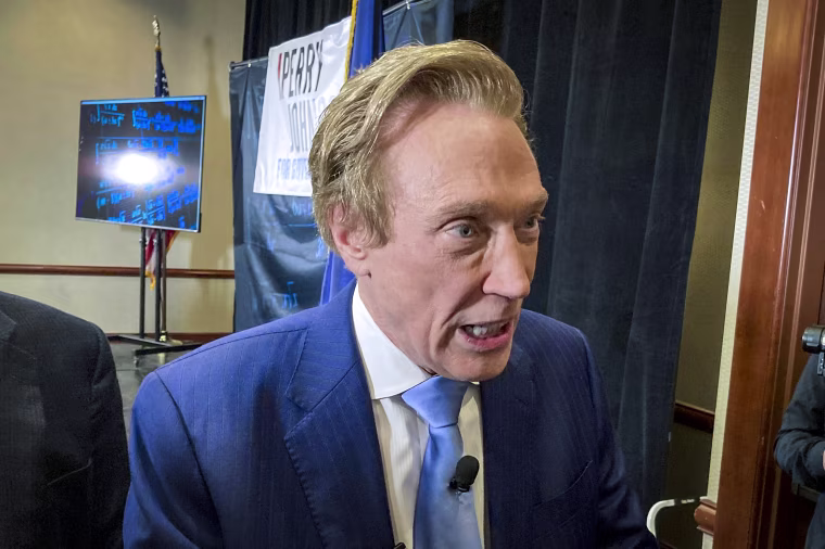 Michigan gubernatorial candidate Perry Johnson, a Republican, briefly speaks with reporters, on Feb. 23, 2022, after a kickoff event at a hotel in Lansing, Mich.