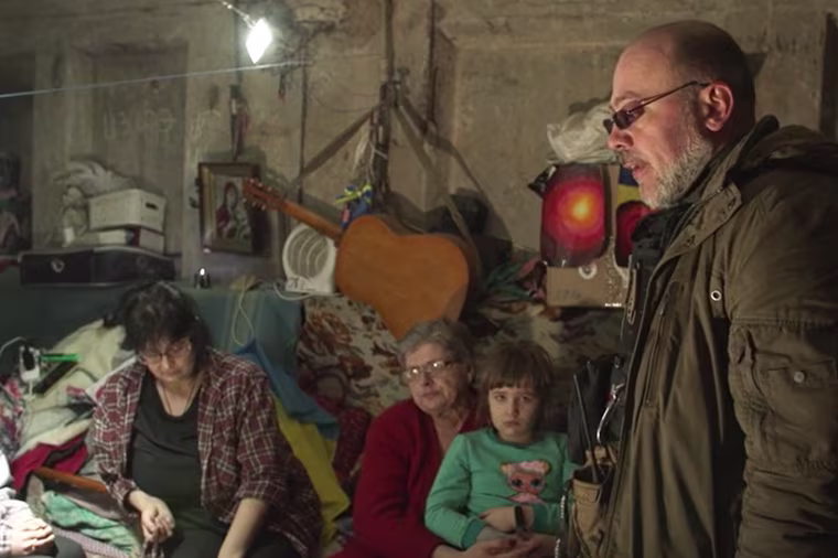The makeshift shelter where the Anapolska family has lived for almost six months. Serhiy Chaus, right, the town's unofficial mayor, has been supplying residents with food and medicine.