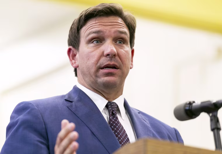 FILE - This May 4 2021 file photo shows Florida Gov. Ron DeSantis, center, speaks during a news conference at West Miami Middle School in Miami. Several states scaled back their reporting of COVID-19 statistics this July 2021, just as cases across the country started to skyrocket, depriving the public of real-time information on outbreaks, cases, hospitalizations and deaths in their communities.