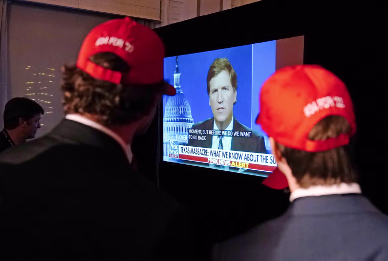 People watch Tucker Carlson during an election night watch party in Atlanta